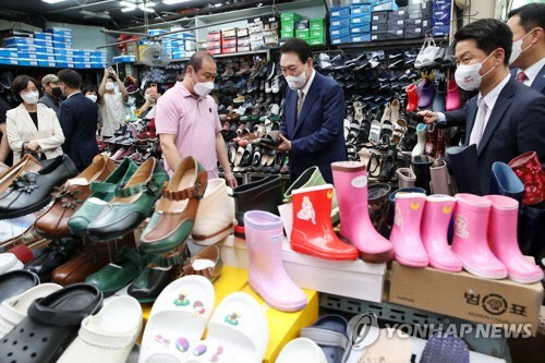 윤석열 대통령이 26일 오후 대구 중구 서문시장 내 한 신발 가게를 방문해 상인과 대화하고 있다.  연합뉴스